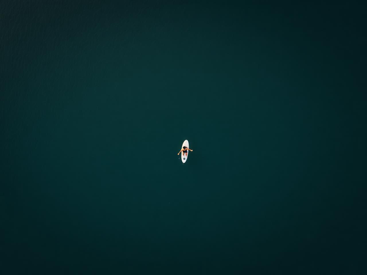 Aerial view of a surfer on calm water